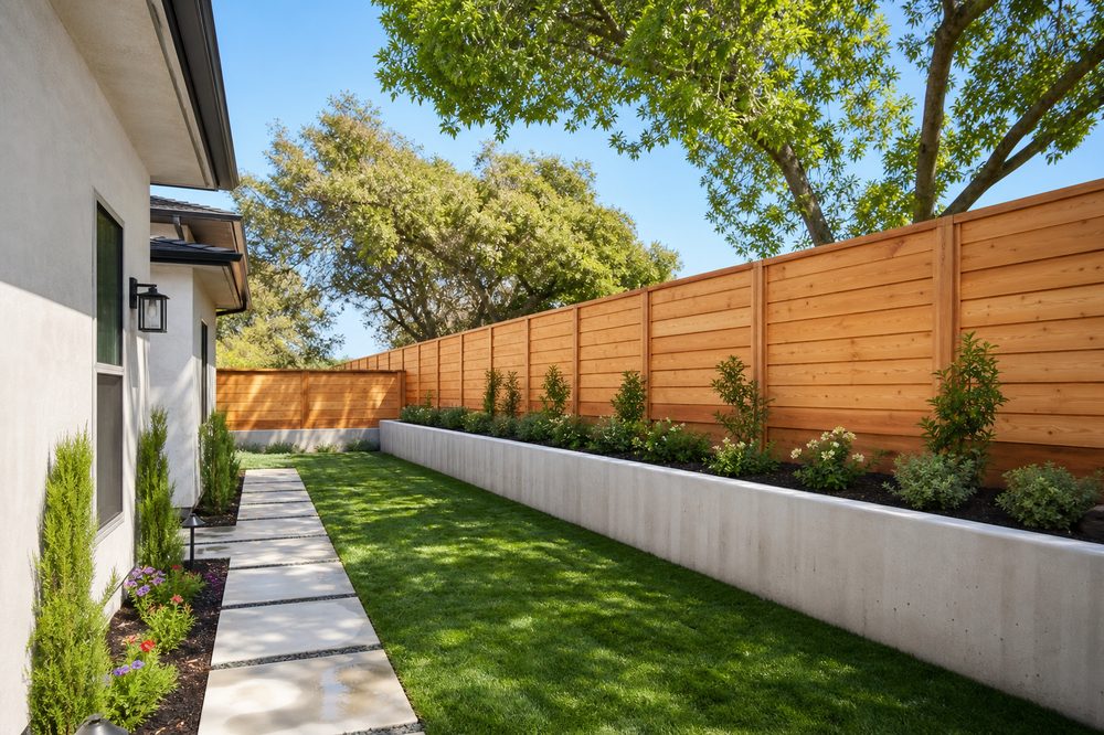Wood fence and concrete retaining wall cleaned by pressure washing